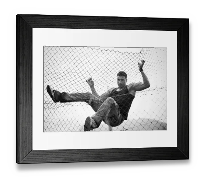 Framed Print : Young man climbing a fence Framed Print : Young man climbing a fence