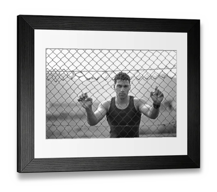 Framed Print : Young man holding onto a fence Framed Print : Young man holding onto a fence