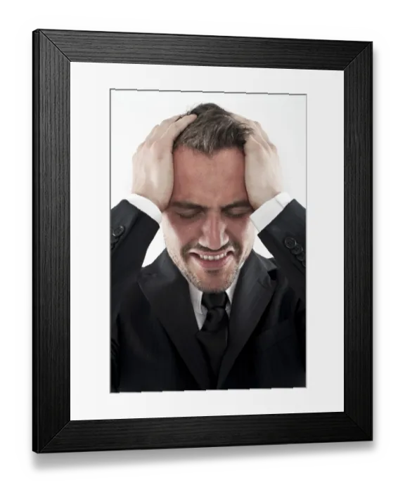Framed Print : Desperate young man wearing a suit holding his hands to his face, worried Framed Print : Desperate young man wearing a suit holding his hands to his face, worried