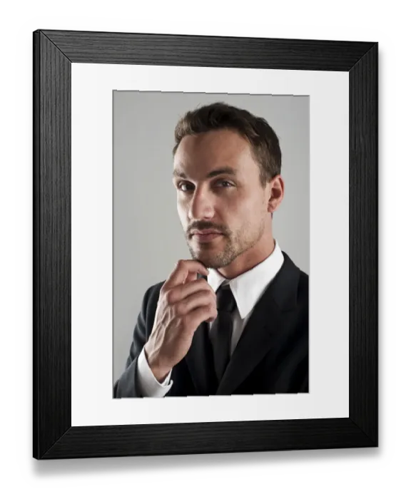 Framed Print : Young businessman wearing a suit with his hand on his chin, pensive, portrait Framed Print : Young businessman wearing a suit with his hand on his chin, pensive, portrait
