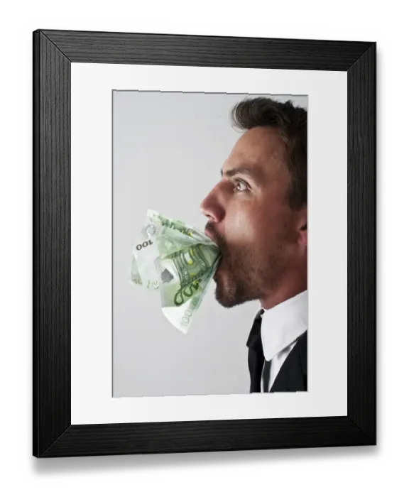 Framed Print : Young man wearing a suit with 100-euro notes stuffed into his mouth Framed Print : Young man wearing a suit with 100-euro notes stuffed into his mouth