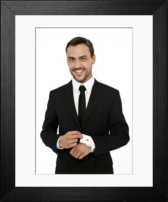 Framed Print : Smiling man wearing a suit pulling several aces out of his sleeve