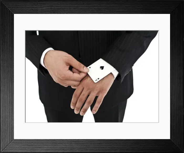 Framed Print : Man wearing a suit pulling an ace of spades out of his sleeve