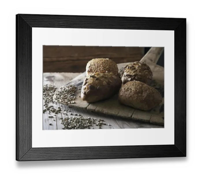 Framed Print : Multigrain bread rolls on old bread slide with rye grains Framed Print : Multigrain bread rolls on old bread slide with rye grains