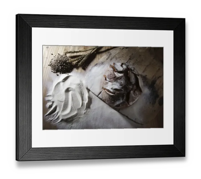 Framed Print : Farmhouse bread on an old bread slide with rye grains, ears and flour on a rustic wooden surface