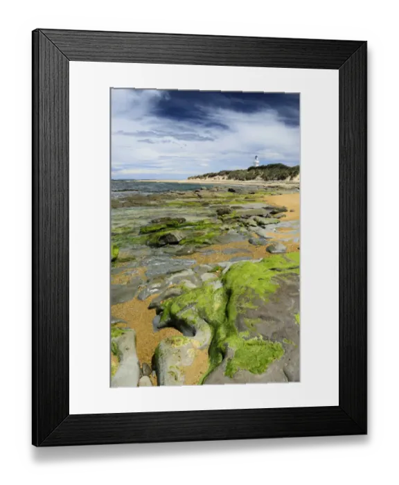 Framed Print : Lighthouse at Waipapa Point with clouds in the sky, algae covered rocks at the front, Otara, Fortrose, Southland Region, South Island, New Zealand