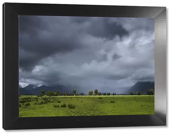 Pastures with storm clouds and rain, South Island, New Zealand