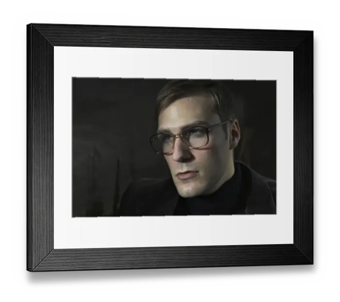 Framed Print : Student wearing a suit and glasses, sitting in front of a painting Framed Print : Student wearing a suit and glasses, sitting in front of a painting