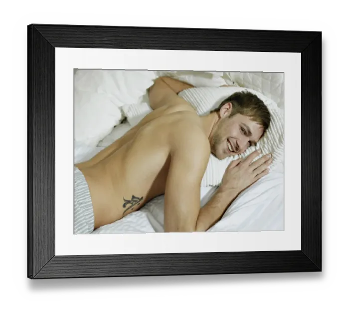 Framed Print : Charming bare chested man wearing pyjamas lying in bed, smiling Framed Print : Charming bare chested man wearing pyjamas lying in bed, smiling