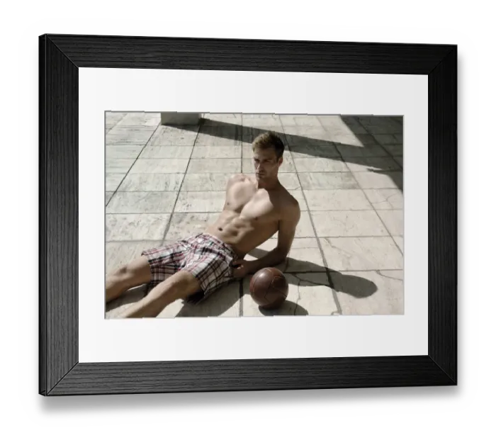Framed Print : Athletic young man in shorts with ball lying on a stone floor Framed Print : Athletic young man in shorts with ball lying on a stone floor