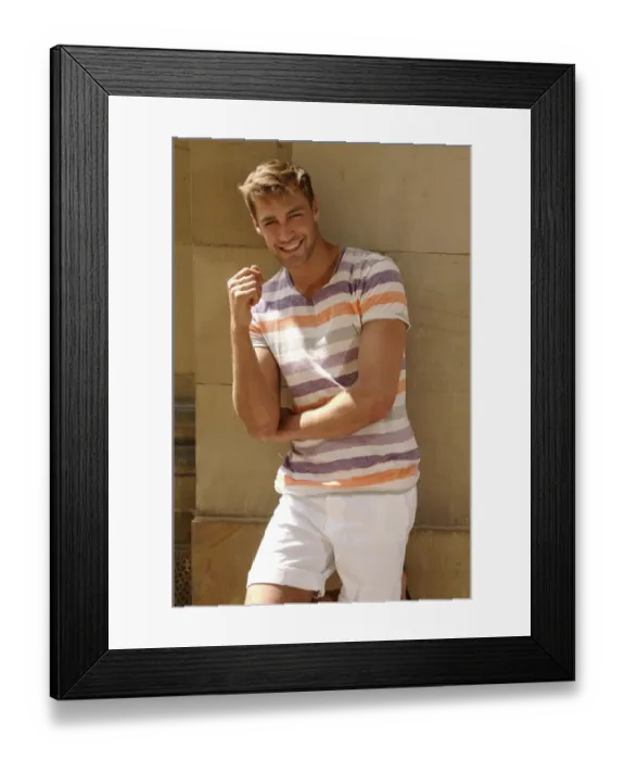 Framed Print : Young man with laptop standing in front of a wall Framed Print : Young man with laptop standing in front of a wall