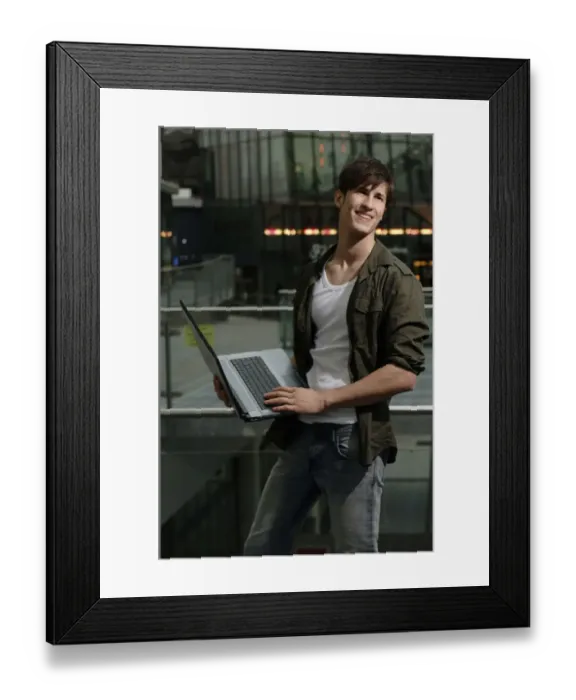 Framed Print : Student holding a laptop computer, smiling Framed Print : Student holding a laptop computer, smiling