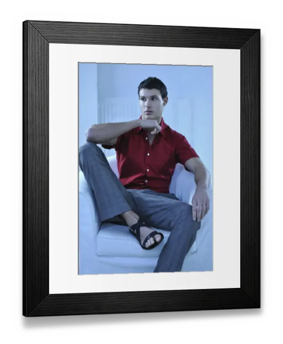 Framed Print : Young man wearing a red shirt sitting in an armchair Framed Print : Young man wearing a red shirt sitting in an armchair