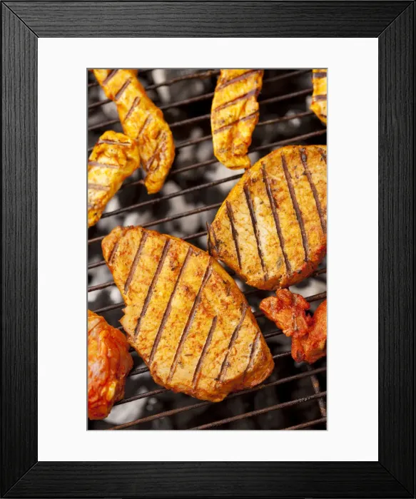 Framed Print : Grilled meat, marinated turkey breast and beef steaks on a grill, hot coals underneath
