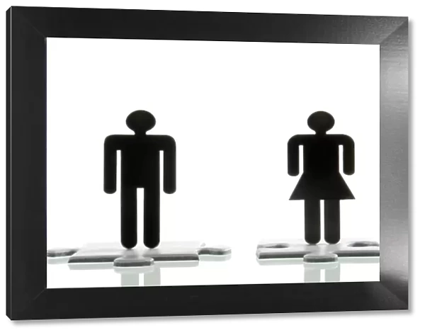 Male figure and a female figure standing on jigsaw puzzle pieces, symbolic image for looking for a partner
