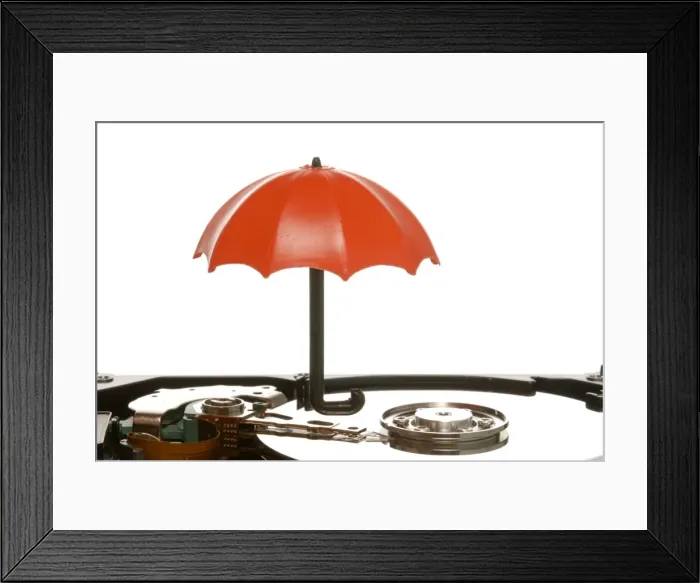 Framed Print : Small umbrella on a hard drive, symbolic image for data protection Framed Print : Small umbrella on a hard drive, symbolic image for data protection