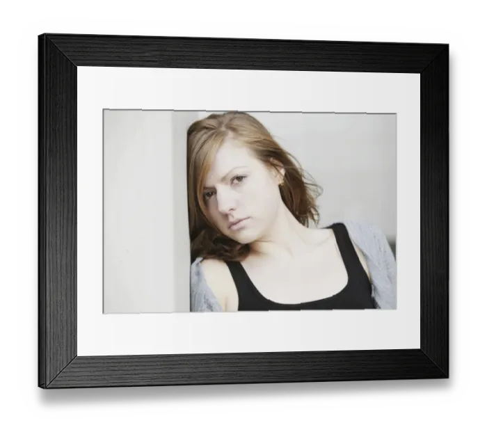 Framed Print : Young woman leaning against a wall, portrait
