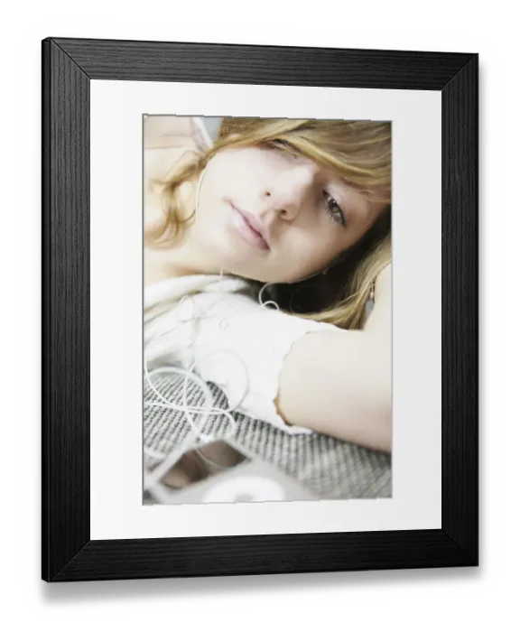 Framed Print : Lying young woman listening to music with MP3 player and headphones Framed Print : Lying young woman listening to music with MP3 player and headphones