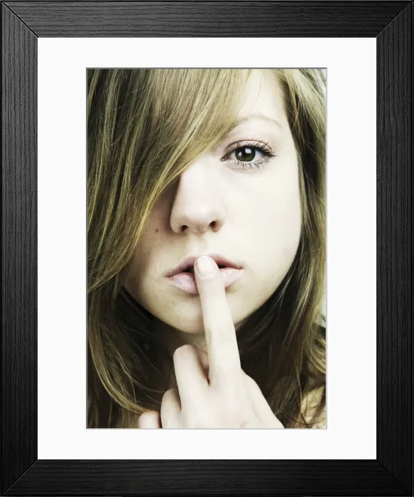 Framed Print : Portrait of a young woman with long hair, finger on her mouth Framed Print : Portrait of a young woman with long hair, finger on her mouth