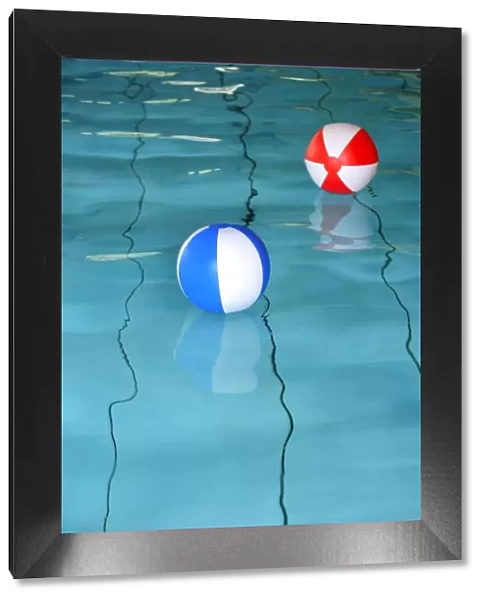 Two beach balls in a swimming pool