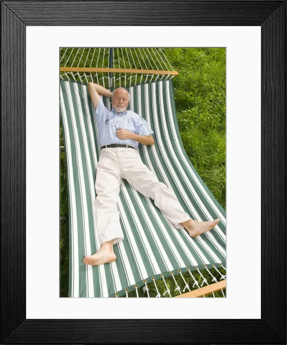 Framed Print : Elderly gentleman lying in a hammock and listening to music Framed Print : Elderly gentleman lying in a hammock and listening to music