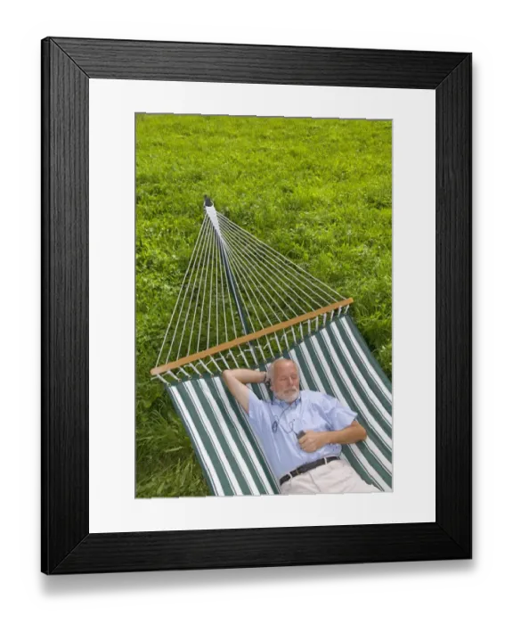 Framed Print : Elderly gentleman lying in a hammock and listening to music Framed Print : Elderly gentleman lying in a hammock and listening to music