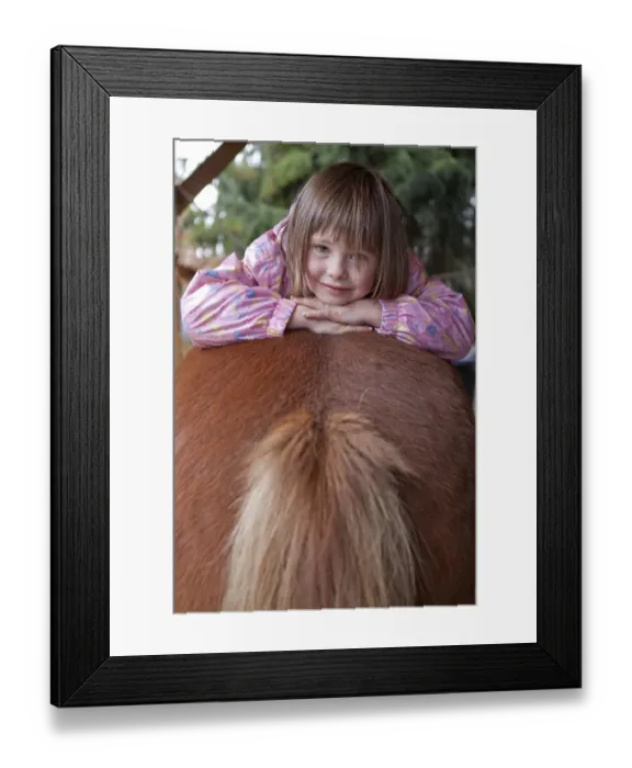 Framed Print : Young girl lying on a pony Framed Print : Young girl lying on a pony