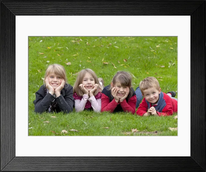 Framed Print : Four children lying on a meadow