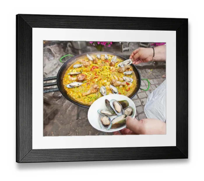 Framed Print : Cook preparing a paella, a Spanish rice dish, adding mussels, series, no. 4