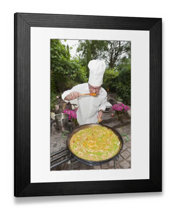 Framed Print : Cook preparing a paella, a Spanish rice dish, adding saffron, tasting, series, no. 1 Framed Print : Cook preparing a paella, a Spanish rice dish, adding saffron, tasting, series, no. 1