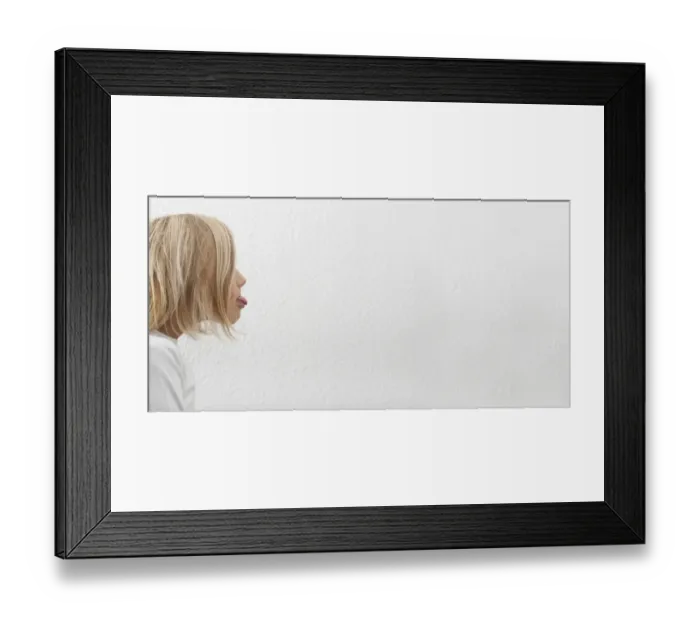 Framed Print : Eight-year-old girl stretching out her tongue Framed Print : Eight-year-old girl stretching out her tongue