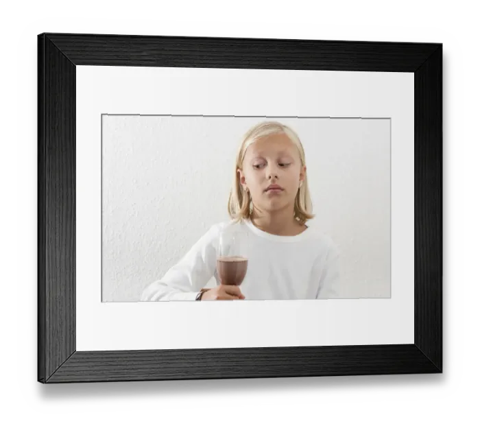 Framed Print : Eight-year-old girl viewing her drink skeptically Framed Print : Eight-year-old girl viewing her drink skeptically