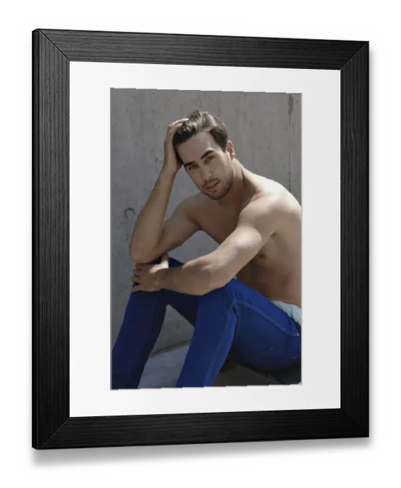 Framed Print : Young shirtless skater in front of a concrete wall, sitting on his skateboard