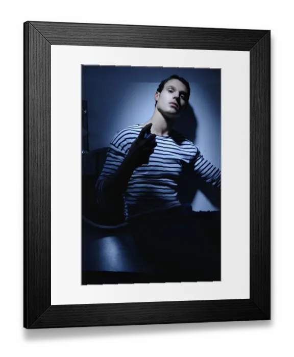Framed Print : Man wearing a striped T-shirt in a bathroom, spraying on perfume Framed Print : Man wearing a striped T-shirt in a bathroom, spraying on perfume