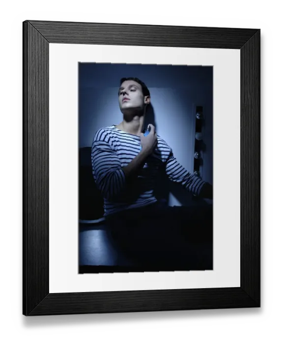 Framed Print : Man wearing a striped T-shirt in a bathroom, spraying on perfume Framed Print : Man wearing a striped T-shirt in a bathroom, spraying on perfume
