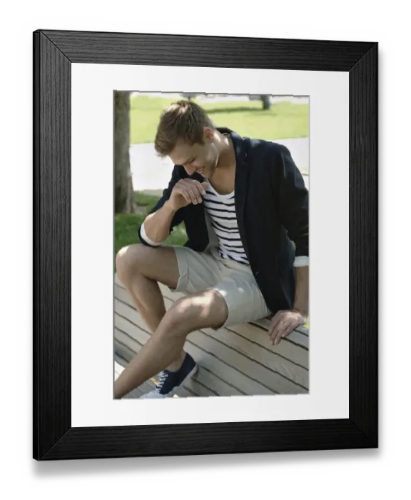 Framed Print : Young man in casual outfit sitting on a park bench in a park Framed Print : Young man in casual outfit sitting on a park bench in a park