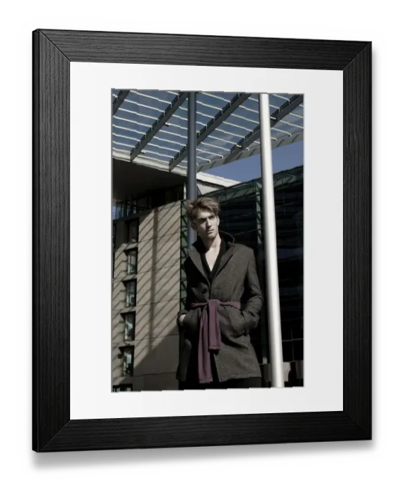Framed Print : Young man wearing an overcoat in front of modern architecture, fashion shoot Framed Print : Young man wearing an overcoat in front of modern architecture, fashion shoot