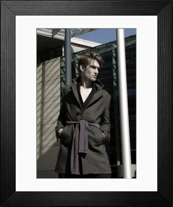 Framed Print : Young man wearing an overcoat in front of modern architecture, fashion shoot Framed Print : Young man wearing an overcoat in front of modern architecture, fashion shoot