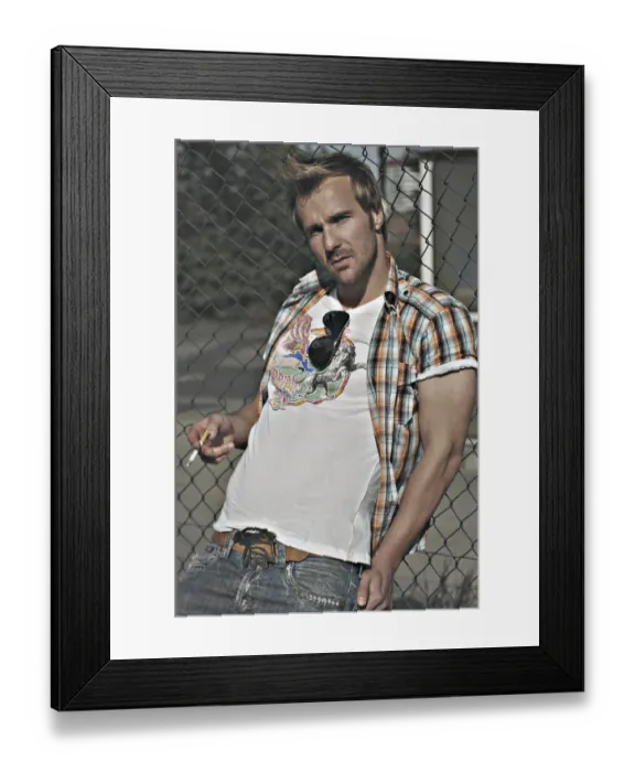 Framed Print : Rebellious man wearing jeans and a plaid shirt at a gas station, smoking Framed Print : Rebellious man wearing jeans and a plaid shirt at a gas station, smoking