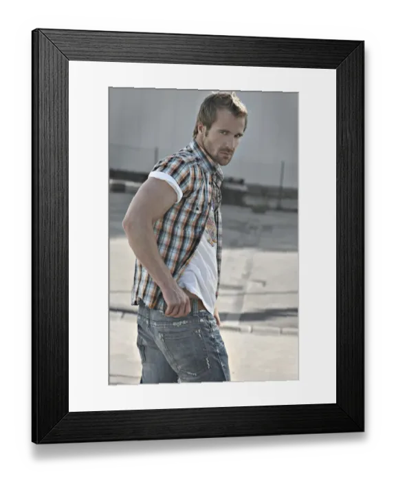 Framed Print : Rebellious man wearing jeans and a plaid shirt at a gas station, turning round Framed Print : Rebellious man wearing jeans and a plaid shirt at a gas station, turning round