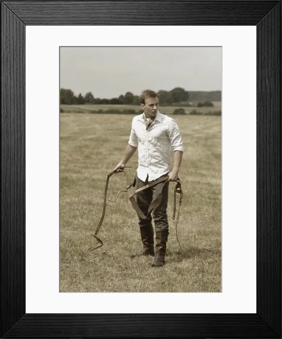 Framed Print : Man wearing riding clothes standing in a field in summer holding a leather strap Framed Print : Man wearing riding clothes standing in a field in summer holding a leather strap