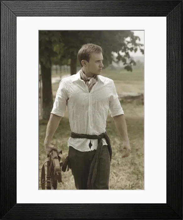 Framed Print : Man wearing riding clothes walking in a field in summer