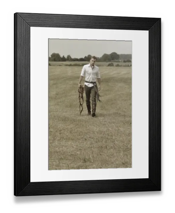 Framed Print : Man wearing riding clothes walking in a field in summer Framed Print : Man wearing riding clothes walking in a field in summer