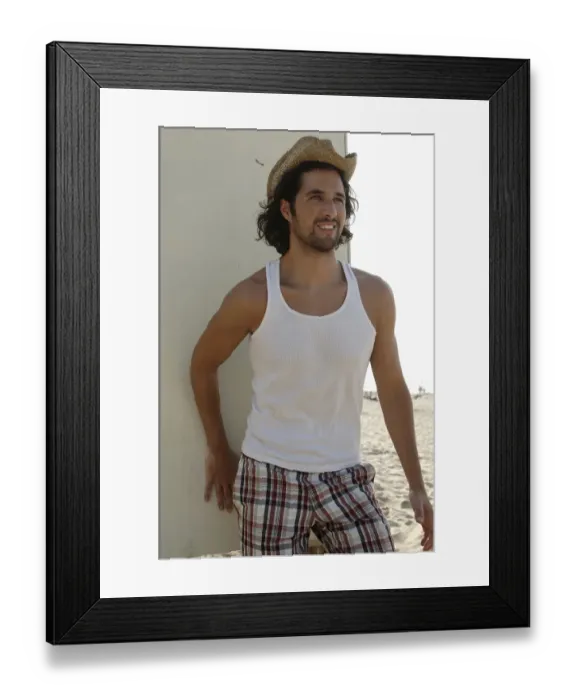Framed Print : Man wearing a sun hat on a beach, leaning against a cottage, smiling Framed Print : Man wearing a sun hat on a beach, leaning against a cottage, smiling