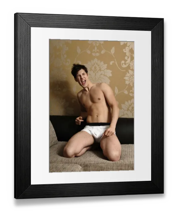 Framed Print : Young man wearing underwear kneeling on a sofa Framed Print : Young man wearing underwear kneeling on a sofa