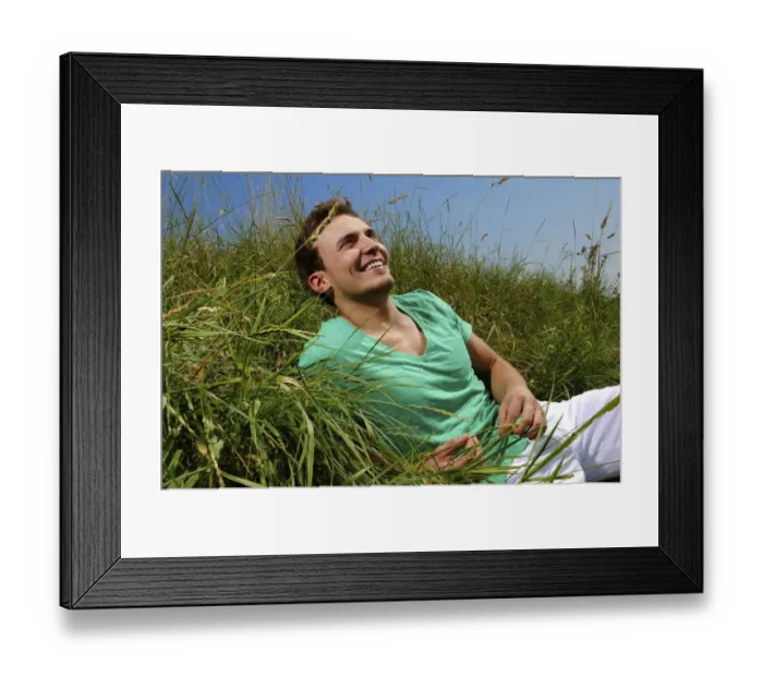 Framed Print : Young man lying in tall grass, smiling, sunbathing