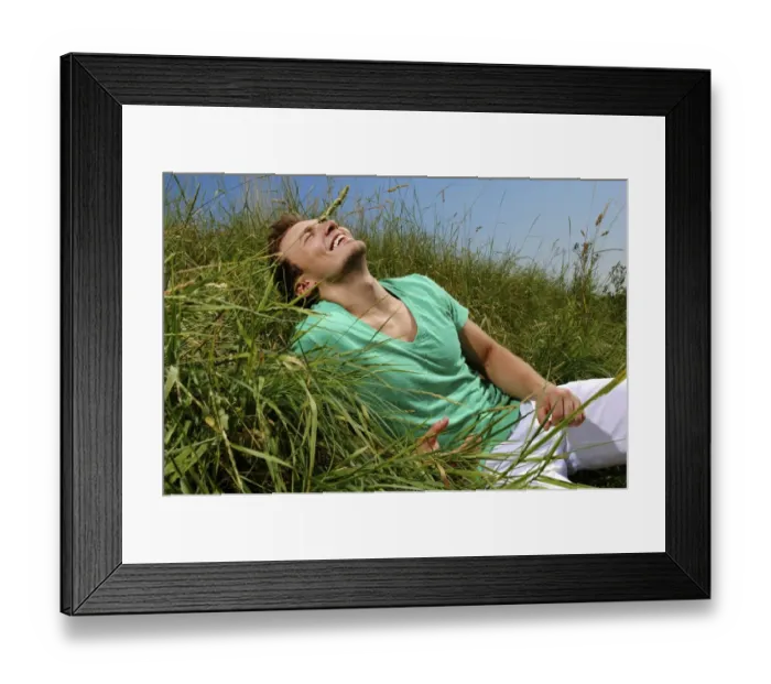Framed Print : Young man lying in tall grass, smiling, sunbathing Framed Print : Young man lying in tall grass, smiling, sunbathing