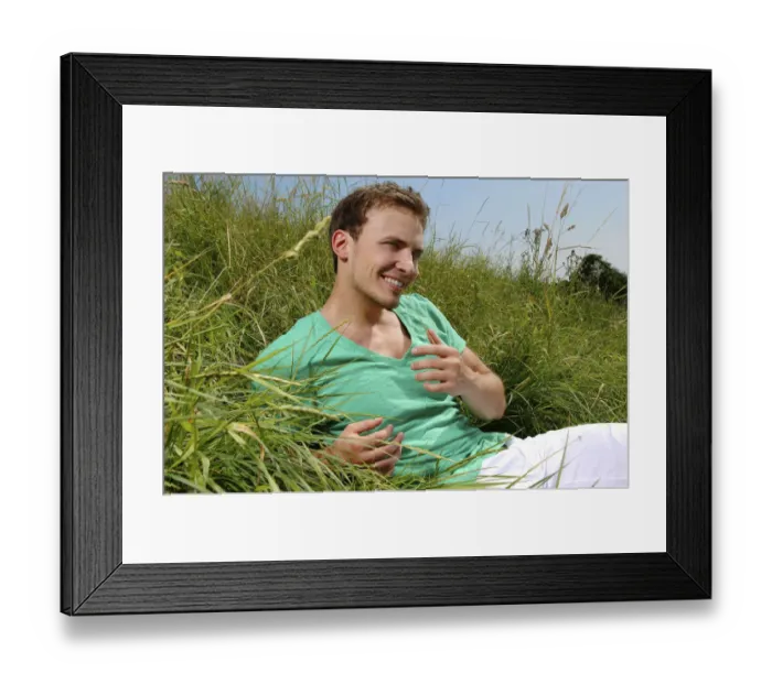 Framed Print : Young man lying in tall grass, smiling, sunbathing Framed Print : Young man lying in tall grass, smiling, sunbathing