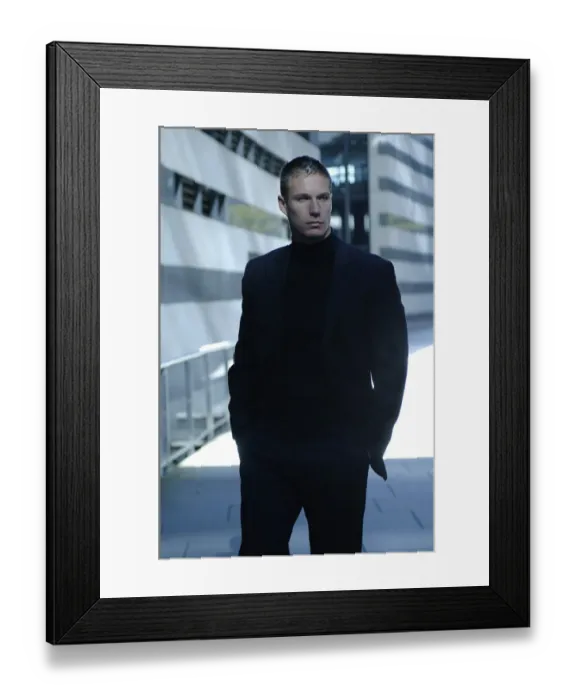 Framed Print : Businessman wearing a dark suit, standing in front of a modern bank building Framed Print : Businessman wearing a dark suit, standing in front of a modern bank building