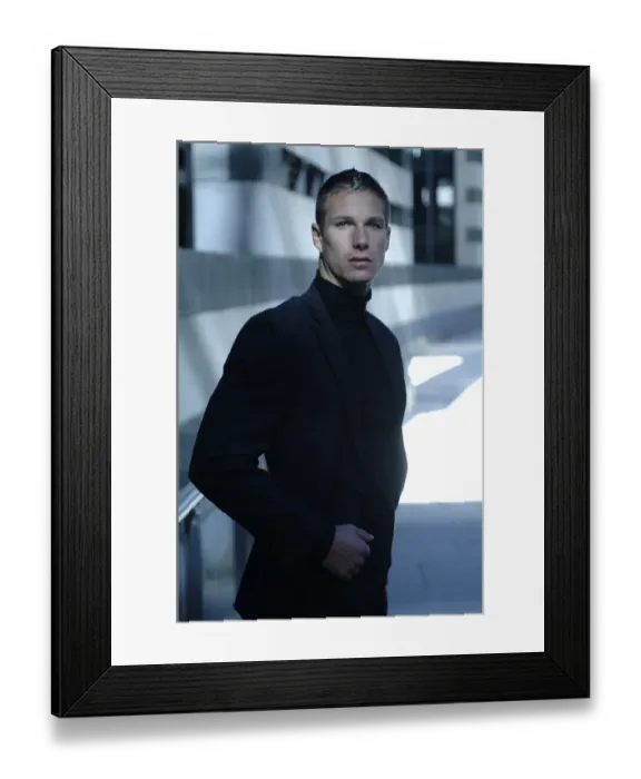Framed Print : Businessman wearing a dark suit, standing in front of a modern bank building Framed Print : Businessman wearing a dark suit, standing in front of a modern bank building